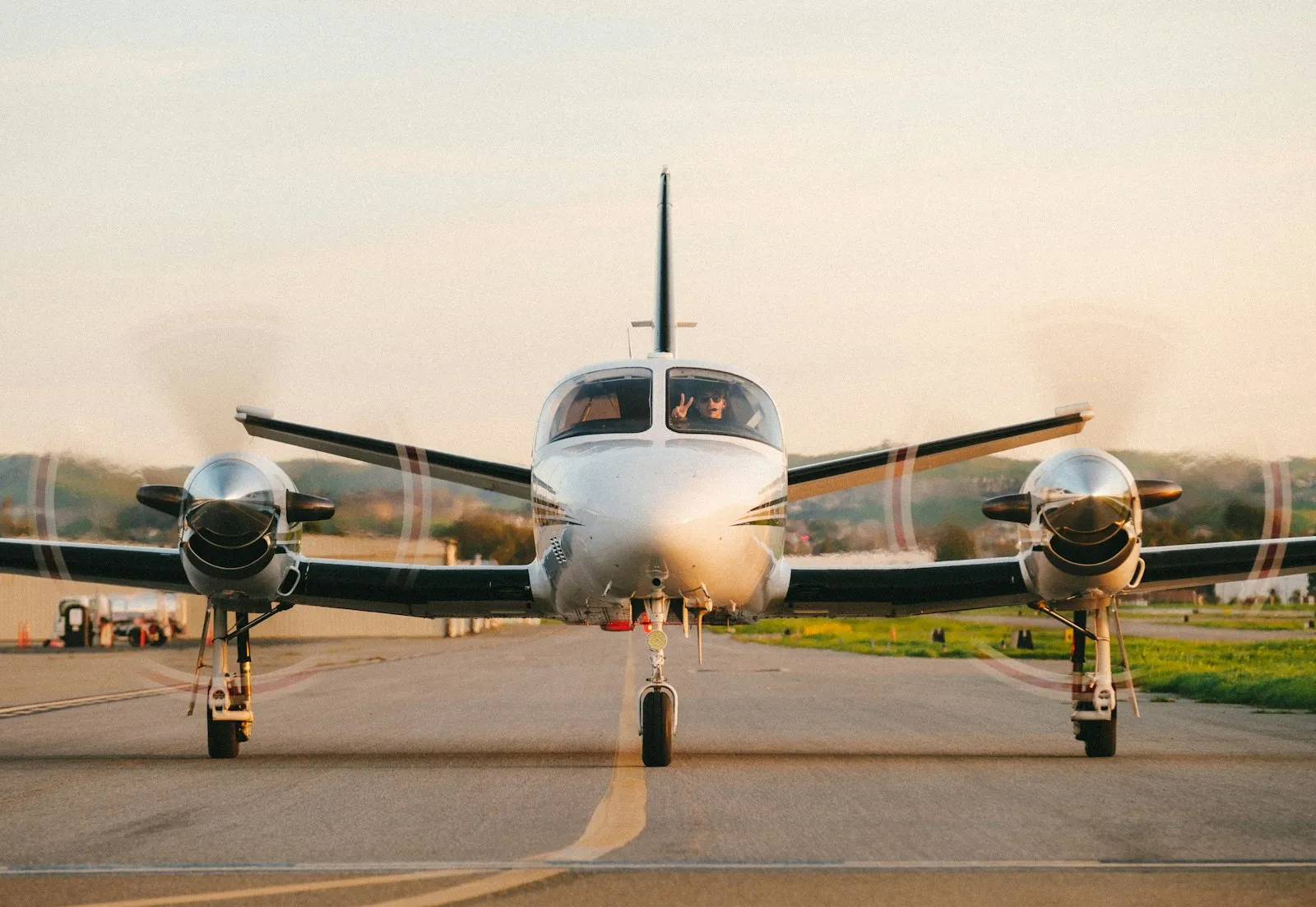 A twin propeller airplane on a runway