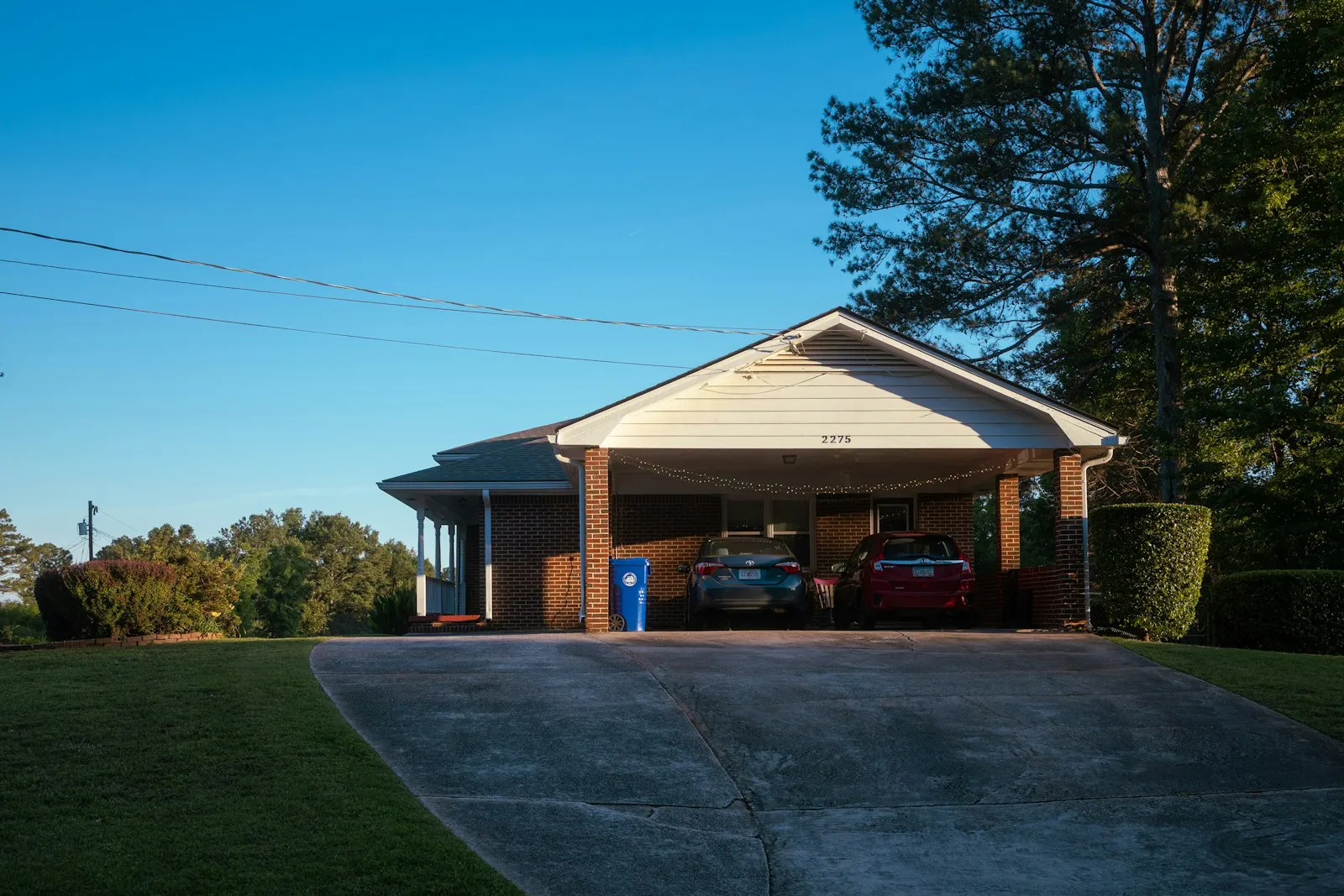 Two cars under a carport at a family home