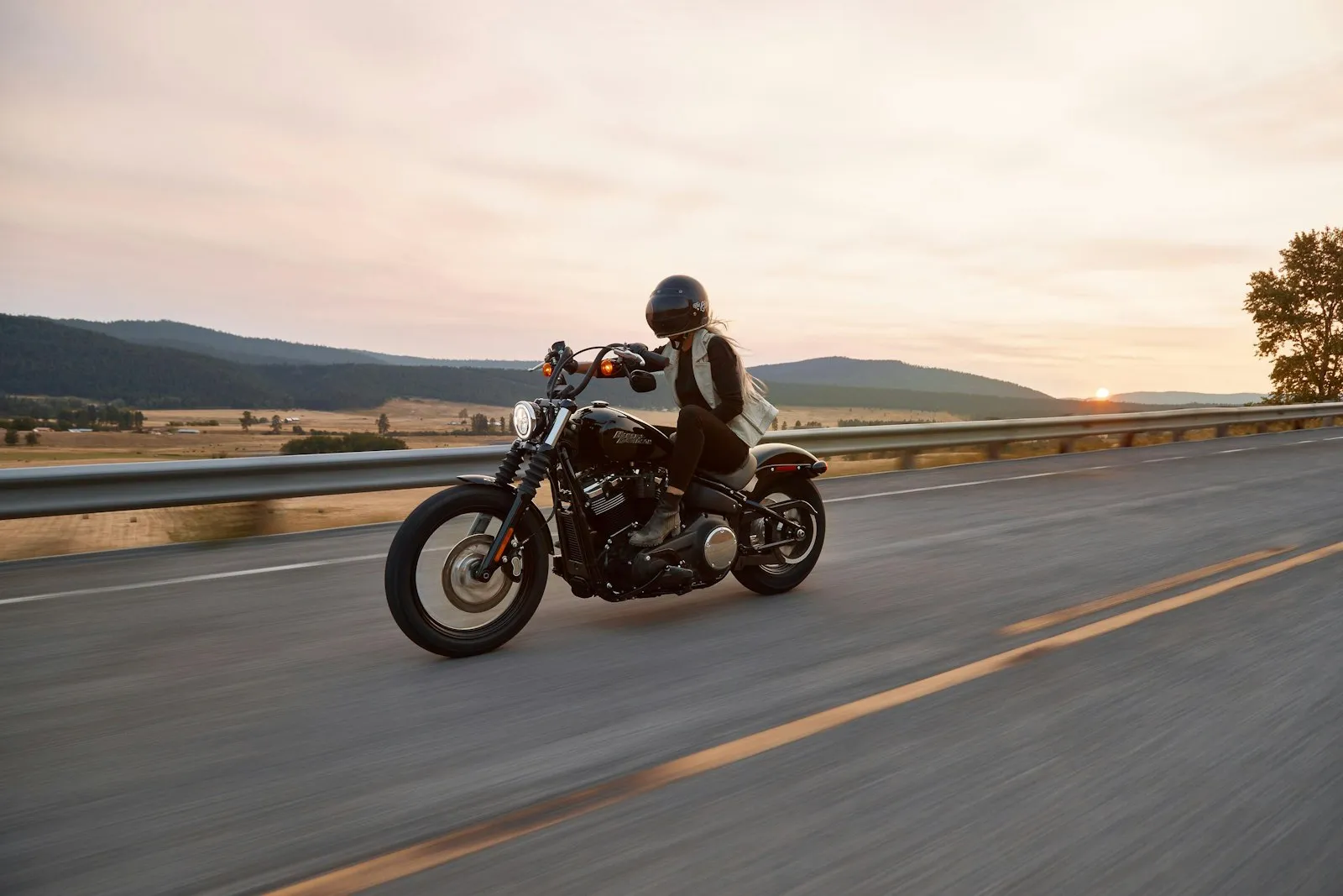 A rider on a cruiser motorcycle on an open highway