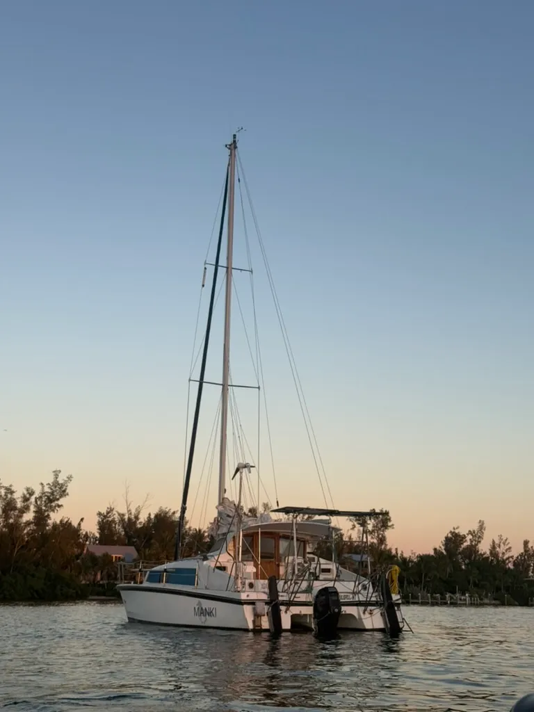 A cruising catamaran at anchor at sunset